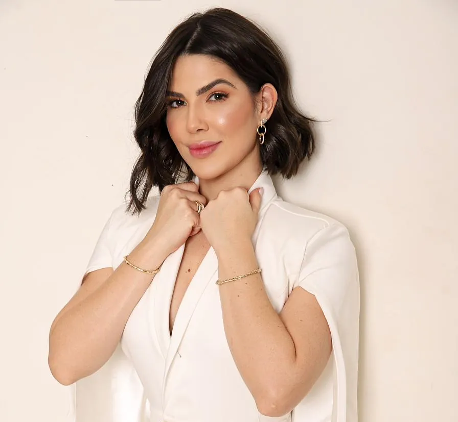Ellen Hernandes de branco, com as mãos na gola do blazer